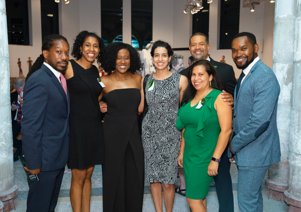 People gather together for a photo at a formal event, all smiling at the camera
